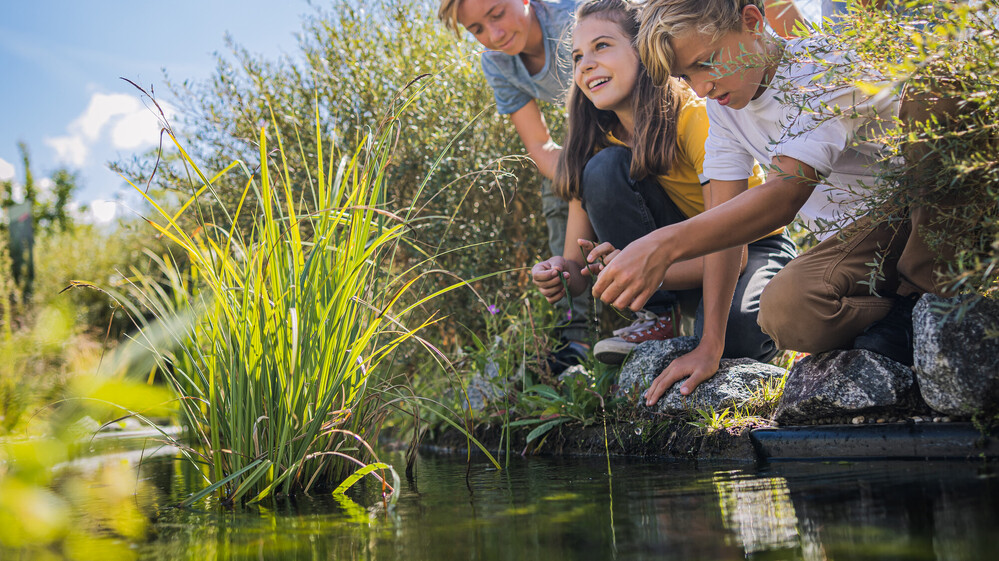 Gruppe Jugendlicher am Teich der Klima Arena